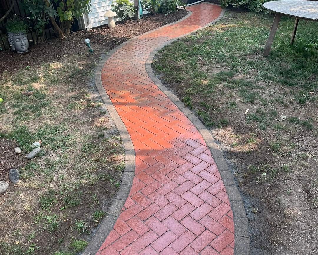 Newly installed curved red brick garden path