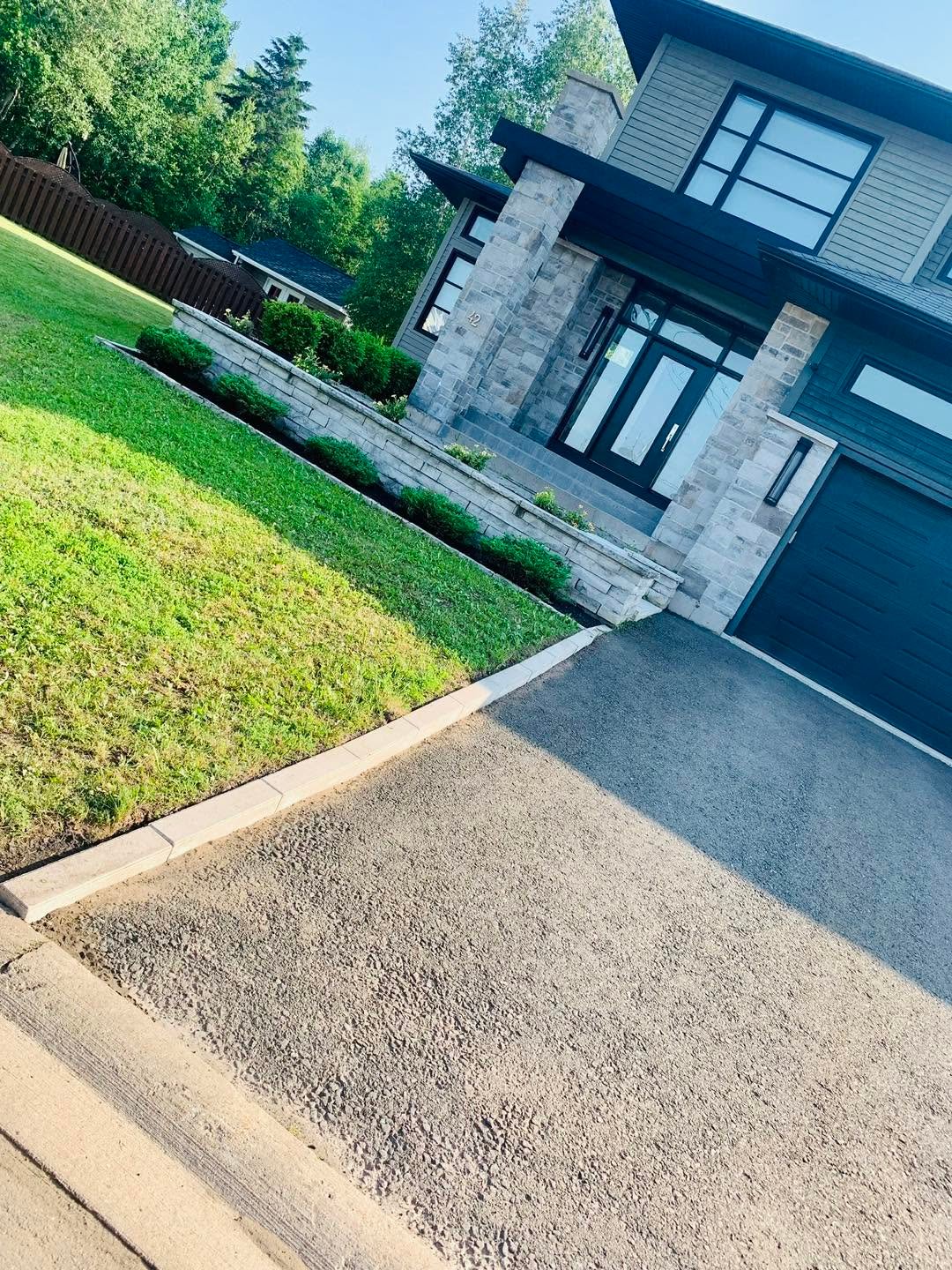 Front entrance with a neat walkway and curved landscape edging