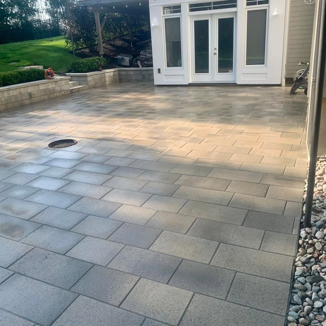 Completed grey paver patio in a backyard living area