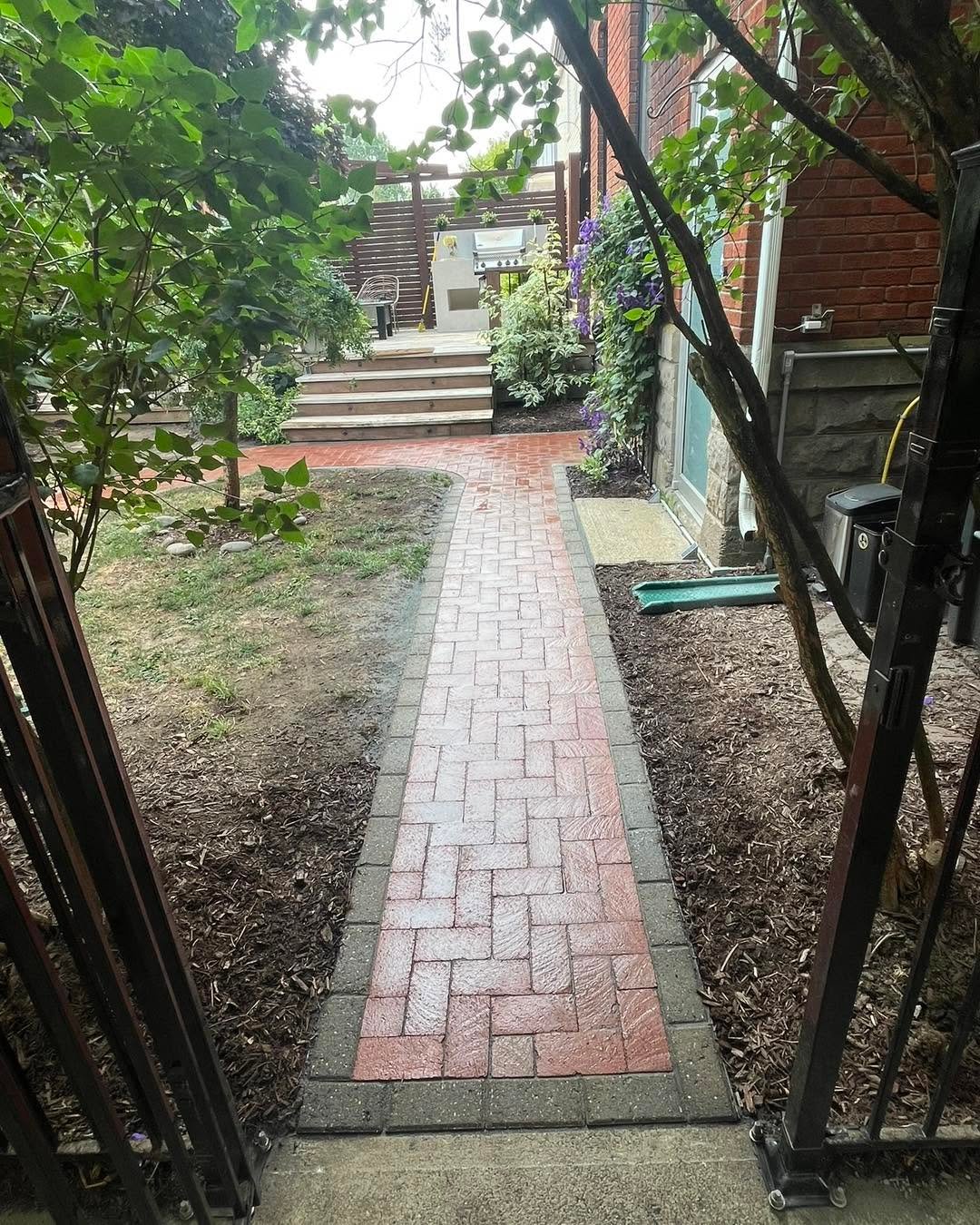 Narrow brick walkway leading through a garden