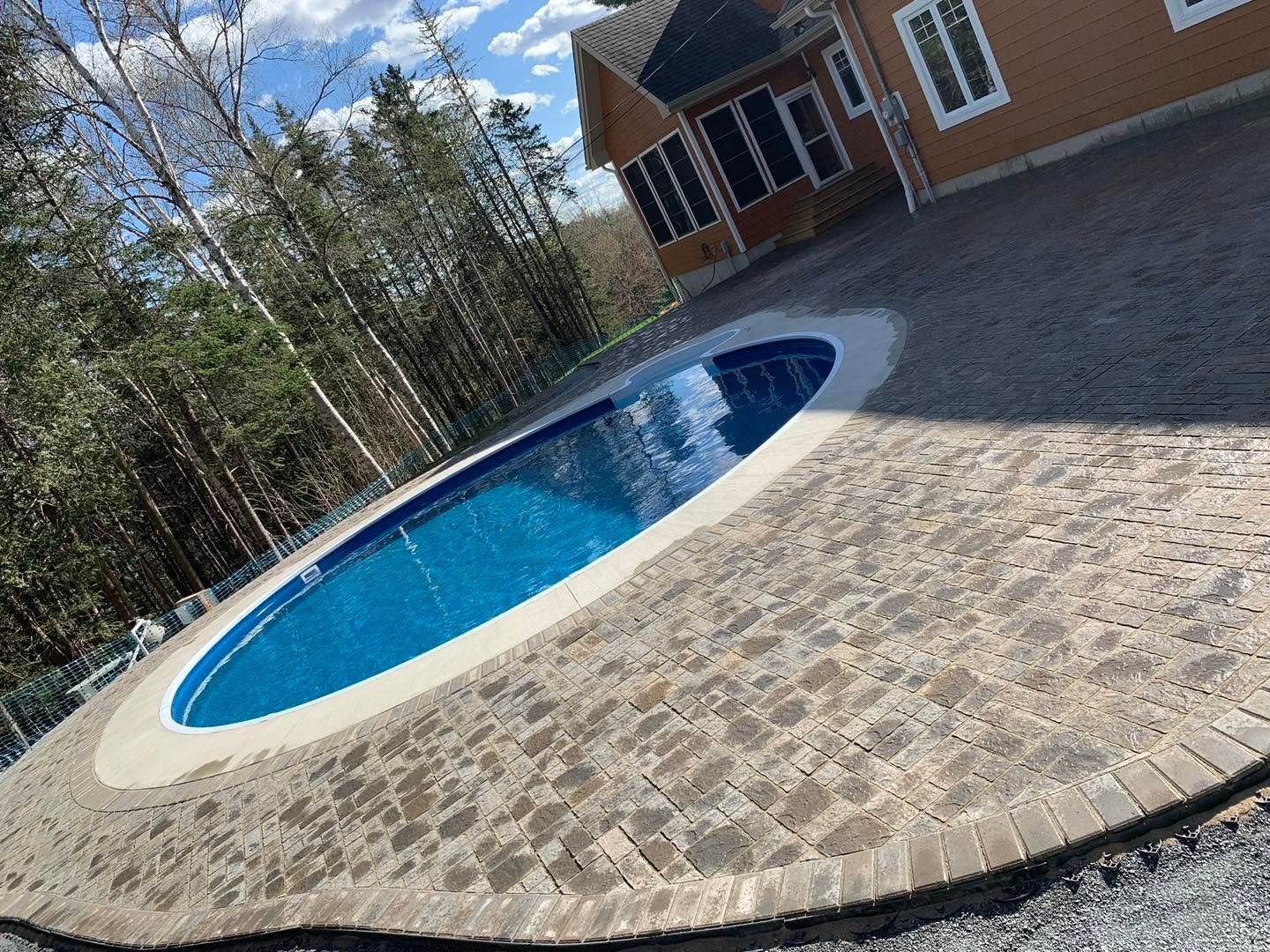 Completed stone paver surround around a backyard pool